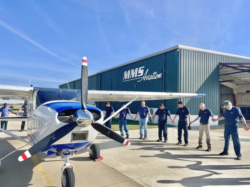 Prayer circle with MMS mechanics before flying away with newly refurbished 182