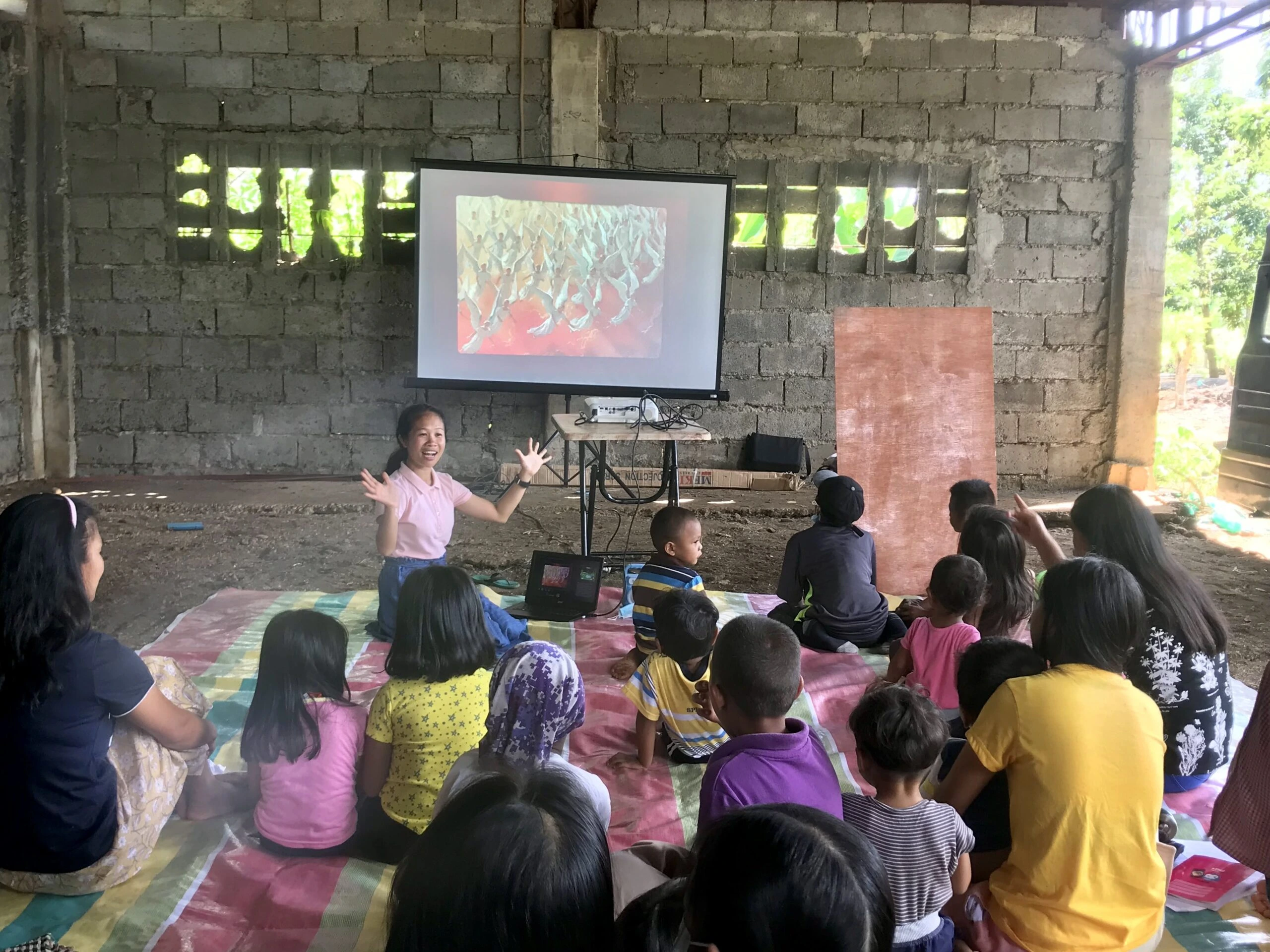 a photo of a PAMAS volunteer teaching little children in the Philippines